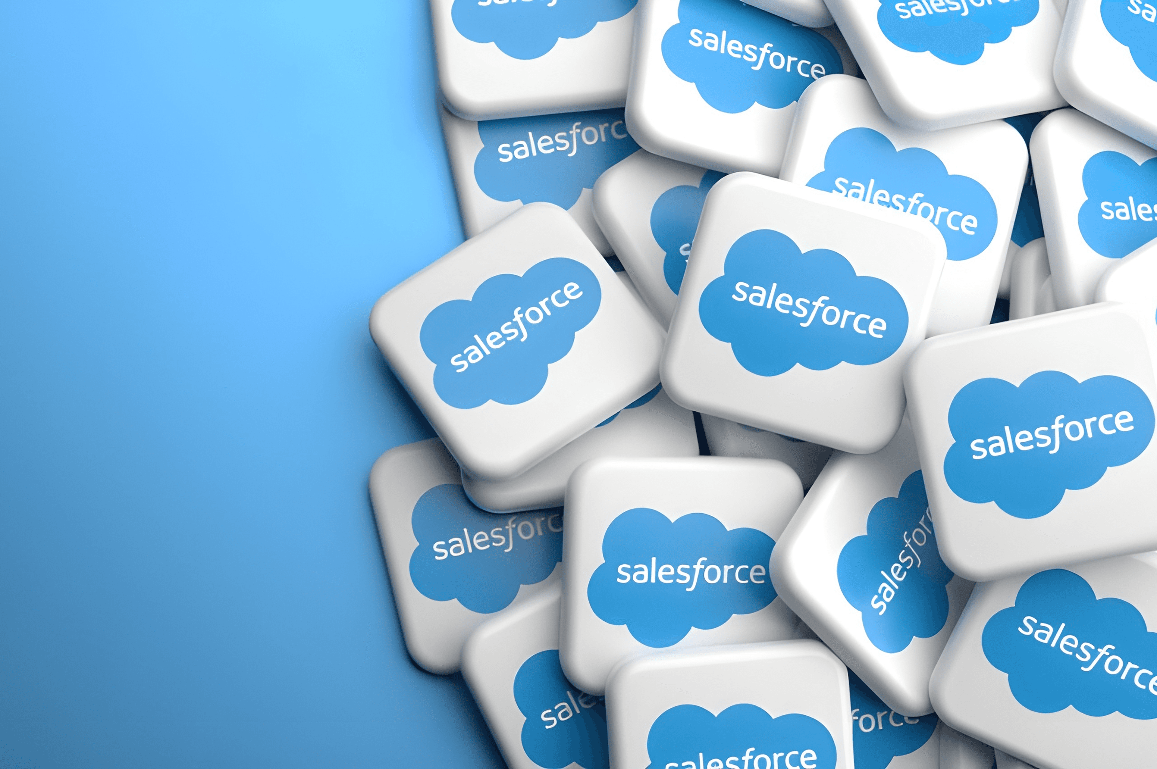 Multiple 3D tiles featuring the Salesforce logo piled together on a blue background.